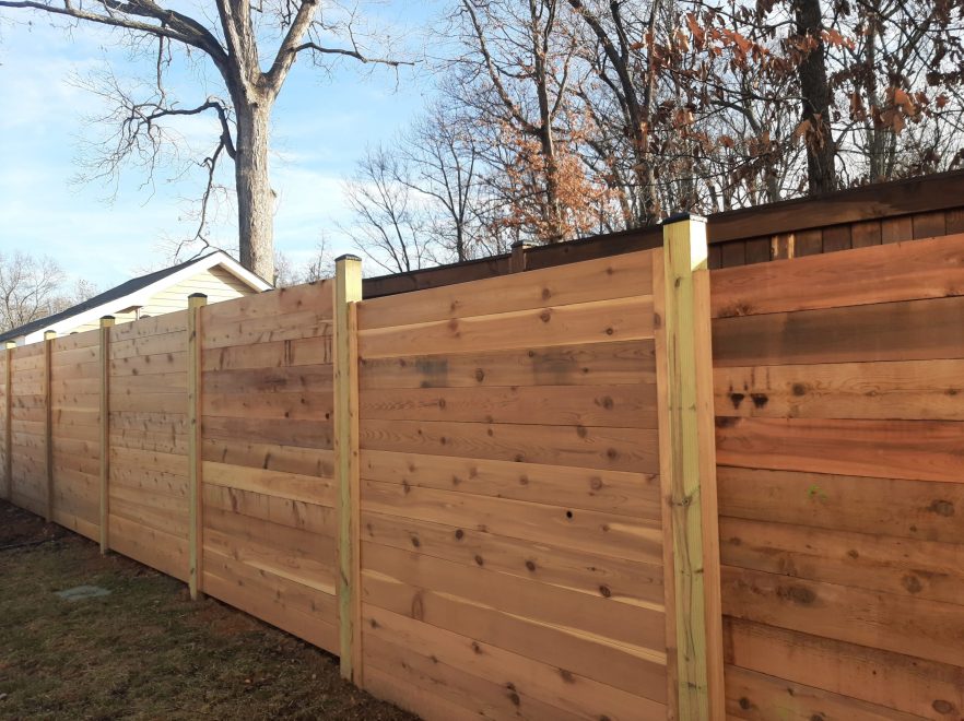 6 foot Horizontal cedar stepped fencing with no spacing between the pickets with standard black post caps