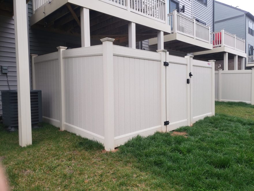 6 foot high tan vinyl privacy fence and walk gate in townhome community