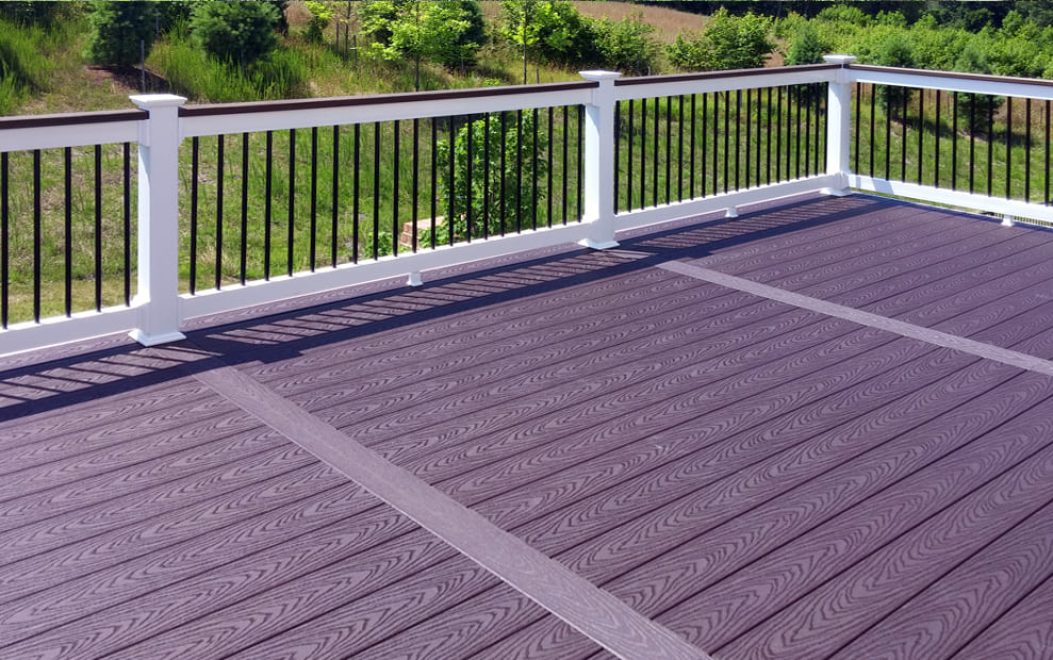 Composite deck with breaker boards and white vinyl railing with matching cap board and black ballusters