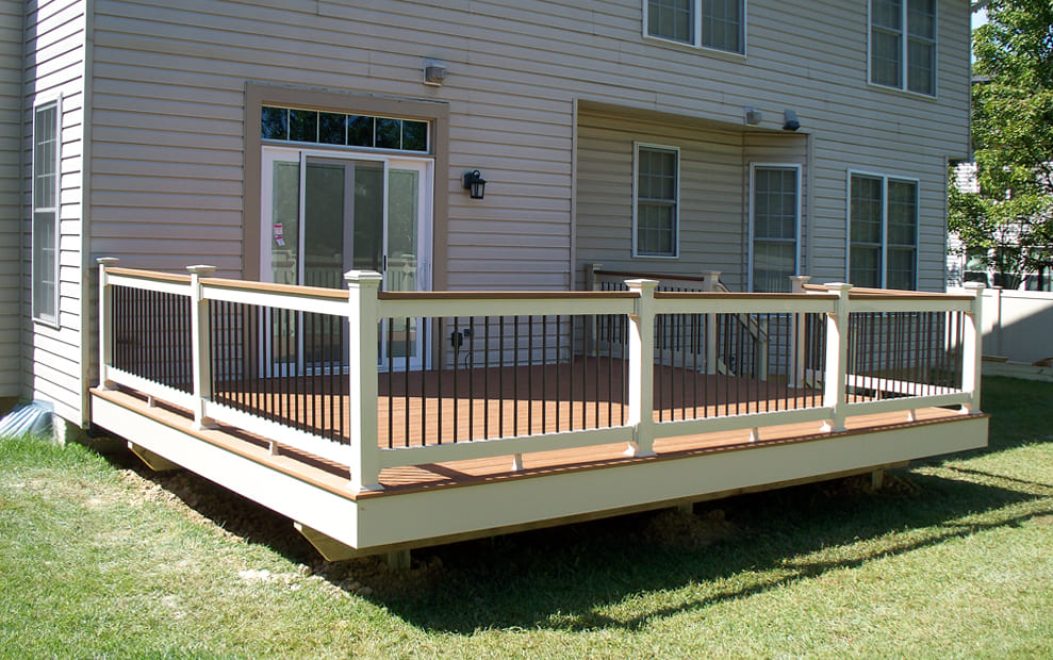 Trex Composite deck with white facia wrap and white vinyl railing with matching cap board and black ballusters