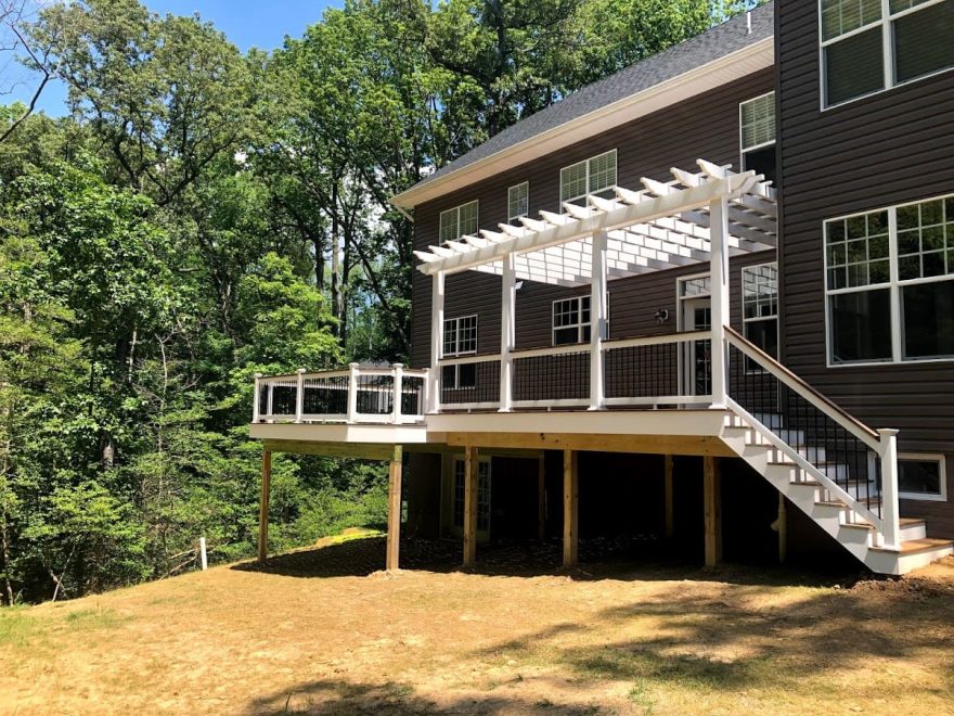 Trex Transcend Havana Gold Decking with White Washington Vinyl Railing and Black Round Aluminum Balusters + Pergola