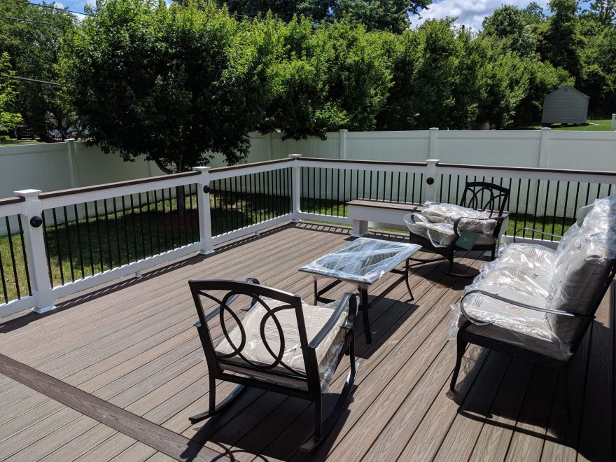 Trex Transcend Spiced Rum Deck Boards with White Lincoln Vinyl Railing, Black Round Aluminum Balusters and matching cocktail rail + black eyeball lights in Ellicott City MD