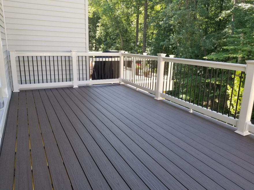 Trex Transcends Spiced Rum deck boards with Tan Washington Vinyl Railing with Black Round Aluminum Balusters in Hanover, MD